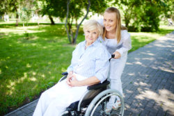 Girl pushing the wheelchair of an old woman